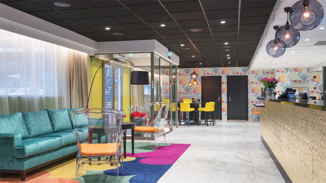 Lobby med sofa, stoler og fargerike tepper på Thon Hotel Tønsberg Brygge