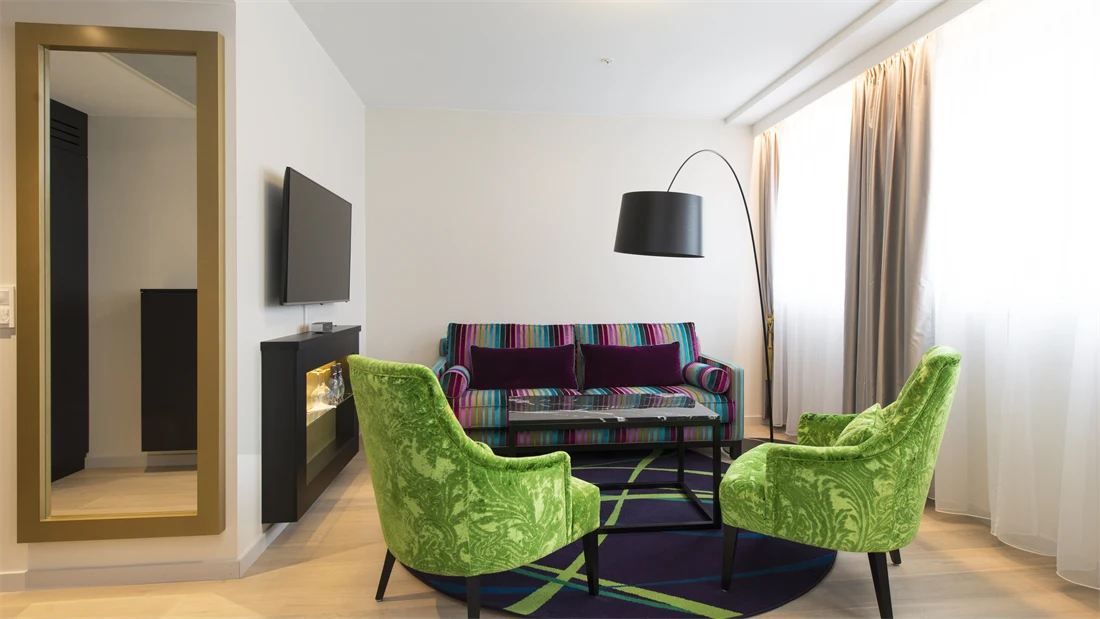 Sittegruppe med sofa og stoler, tv og lampe i buisness room på Thon Hotel Rosenkrantz Oslo, som ligger i Oslo sentrum