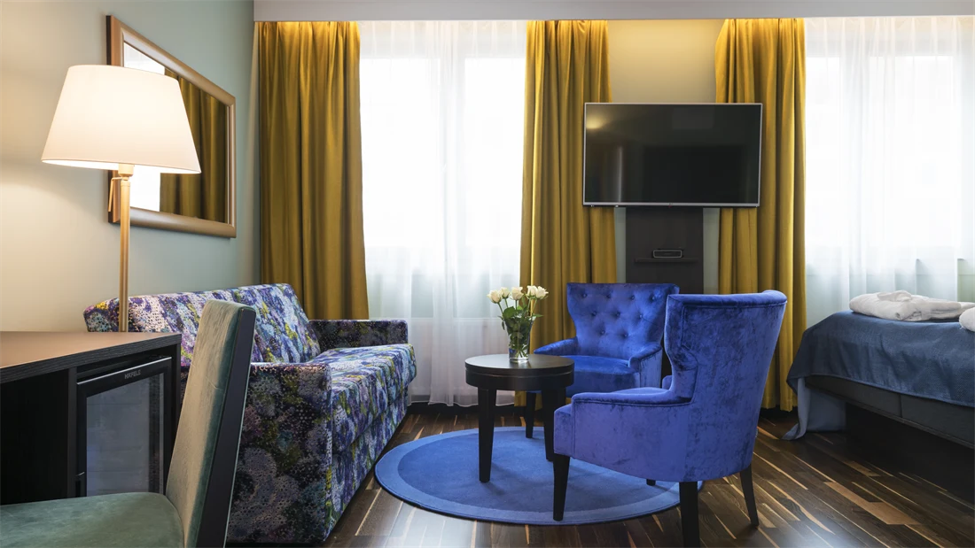 Dobbeltseng med morgenkåpe og tøfler, sittegruppe og smart-TV i superiorrom på Thon Hotel Orion i Bergen sentrum. 